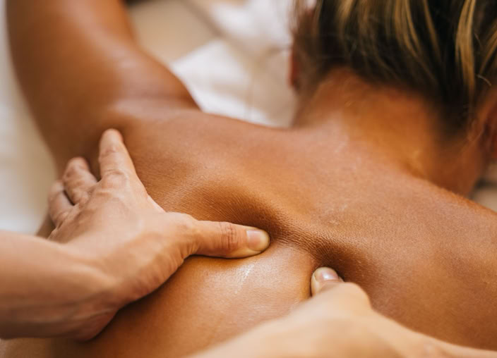 A woman enjoying a relaxing back massage in a spa setting, promoting wellness and relaxation.