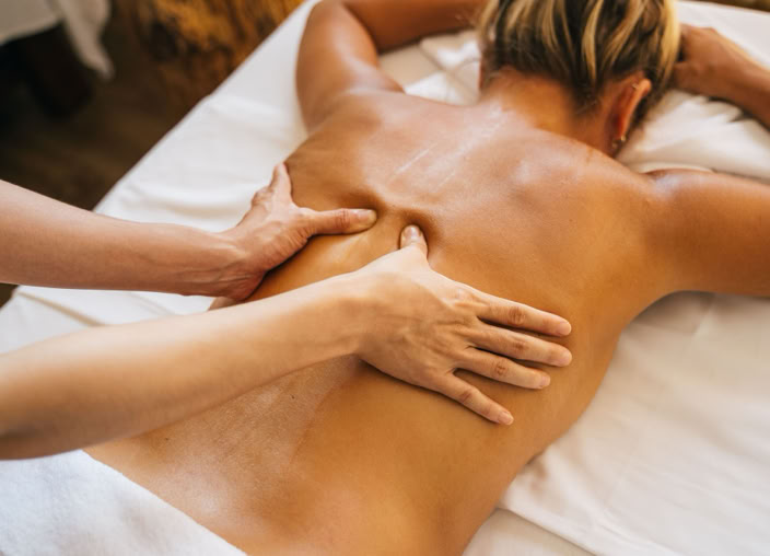 A woman enjoying a relaxing back massage in a spa setting, promoting wellness and relaxation.
