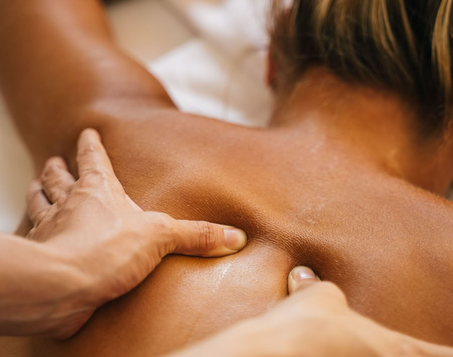 A woman enjoying a relaxing back massage in a spa setting, promoting wellness and relaxation.